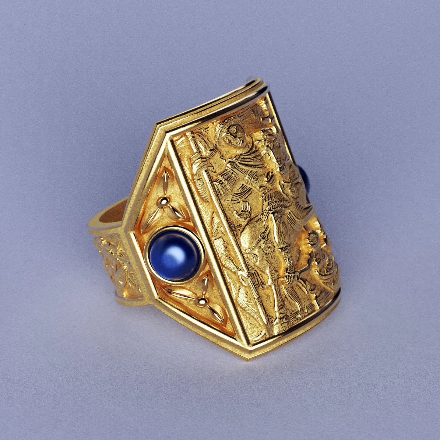 Gold ring with cabochon sapphires and Byzantine-style relief sculpture, featuring intricate details and a regal design.