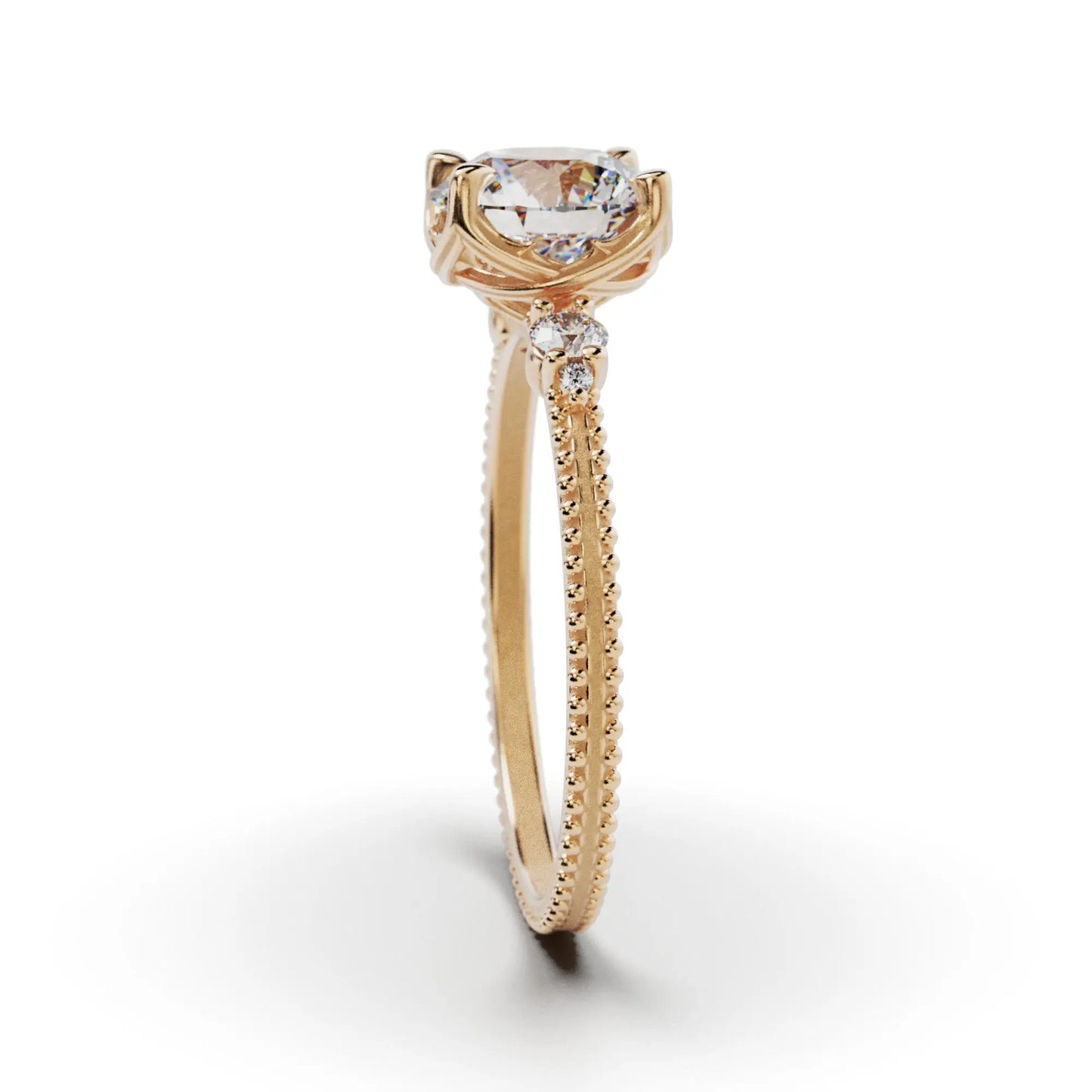 A solitaire diamond ring from the Amore collection, featuring a round-cut diamond in a Venetian-style four-pronged setting. The gold band, available in 14 or 18K, is detailed with milgrane and accented with four smaller diamonds, inspired by Venetian architecture’s timeless romance and artistry.