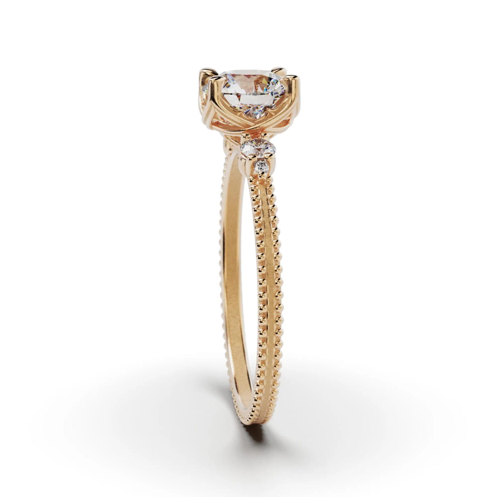 A solitaire diamond ring from the Amore collection, featuring a round-cut diamond in a Venetian-style four-pronged setting. The gold band, available in 14 or 18K, is detailed with milgrane and accented with four smaller diamonds, inspired by Venetian architecture’s timeless romance and artistry.