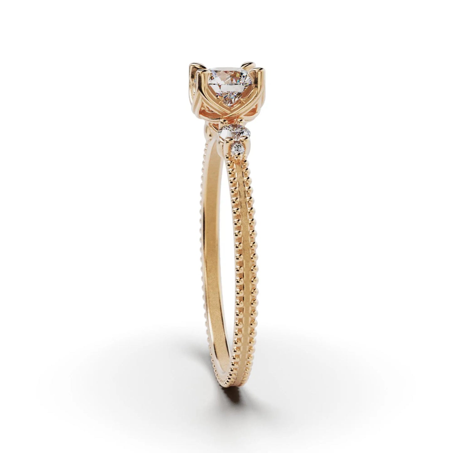 A solitaire diamond ring from the Amore collection, featuring a round-cut diamond in a Venetian-style four-pronged setting. The gold band, available in 14 or 18K, is detailed with milgrane and accented with four smaller diamonds, inspired by Venetian architecture’s timeless romance and artistry.