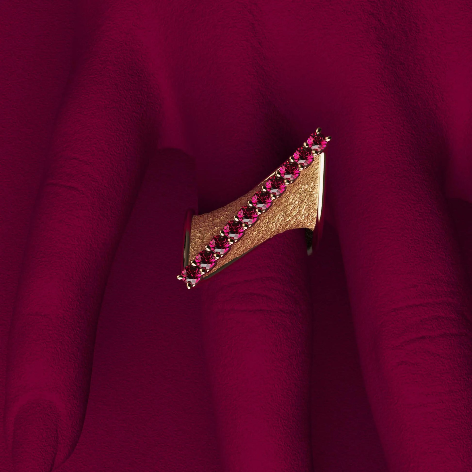 
A modern twisted gold ring with polished edges and an earth-textured surface, featuring 10 round natural rubies set along the top ridge.