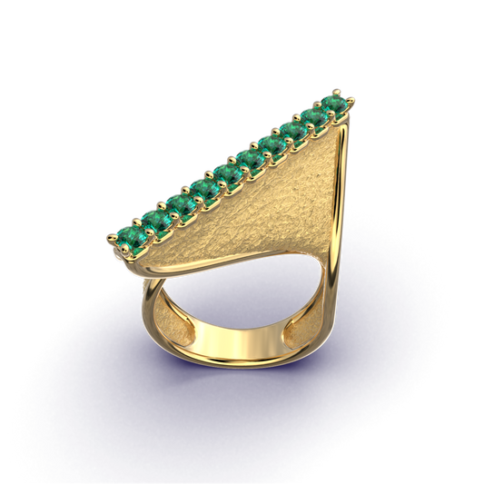 A modern twisted gold ring featuring 10 round natural emeralds set along the top ridge, with polished edges and an earth-textured surface.