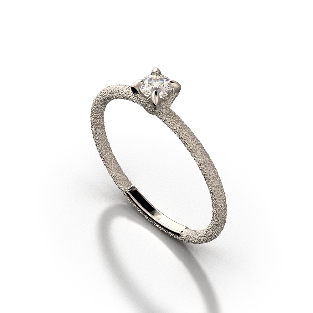 A stunning Italian handmade ring featuring a round, natural white diamond, measuring approximately 3.5mm in diameter and weighing 0.16 carats. The diamond is set on a sleek, handcrafted 18k or 14k solid gold band, meticulously textured to create a striking sparkle effect. The band is approximately 1.6mm wide and 1.6mm thick, enhancing the diamond's brilliance.