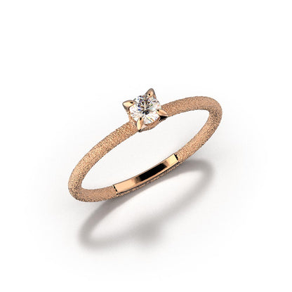 A stunning Italian handmade ring featuring a round, natural white diamond, measuring approximately 3.5mm in diameter and weighing 0.16 carats. The diamond is set on a sleek, handcrafted 18k or 14k solid gold band, meticulously textured to create a striking sparkle effect. The band is approximately 1.6mm wide and 1.6mm thick, enhancing the diamond's brilliance.